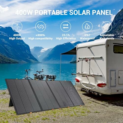 Portable solar panel by a lake with mountains and an RV in the background.